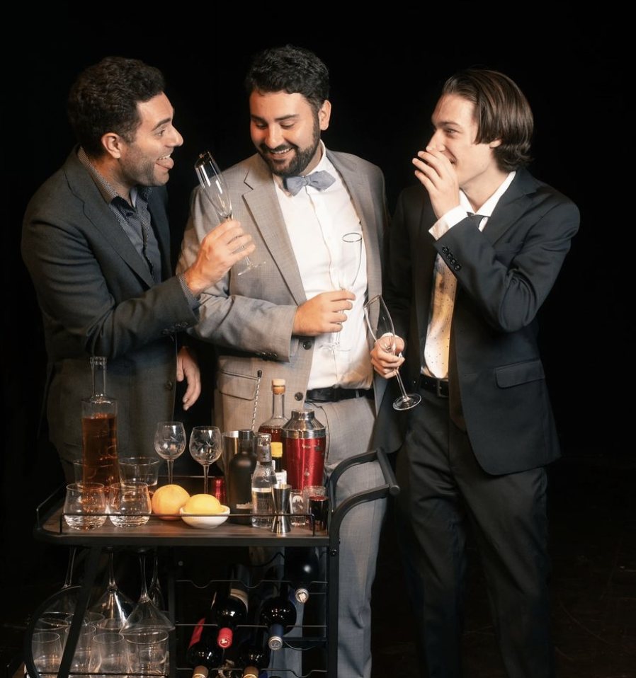 picture of three men standing over a bar cart on stage 